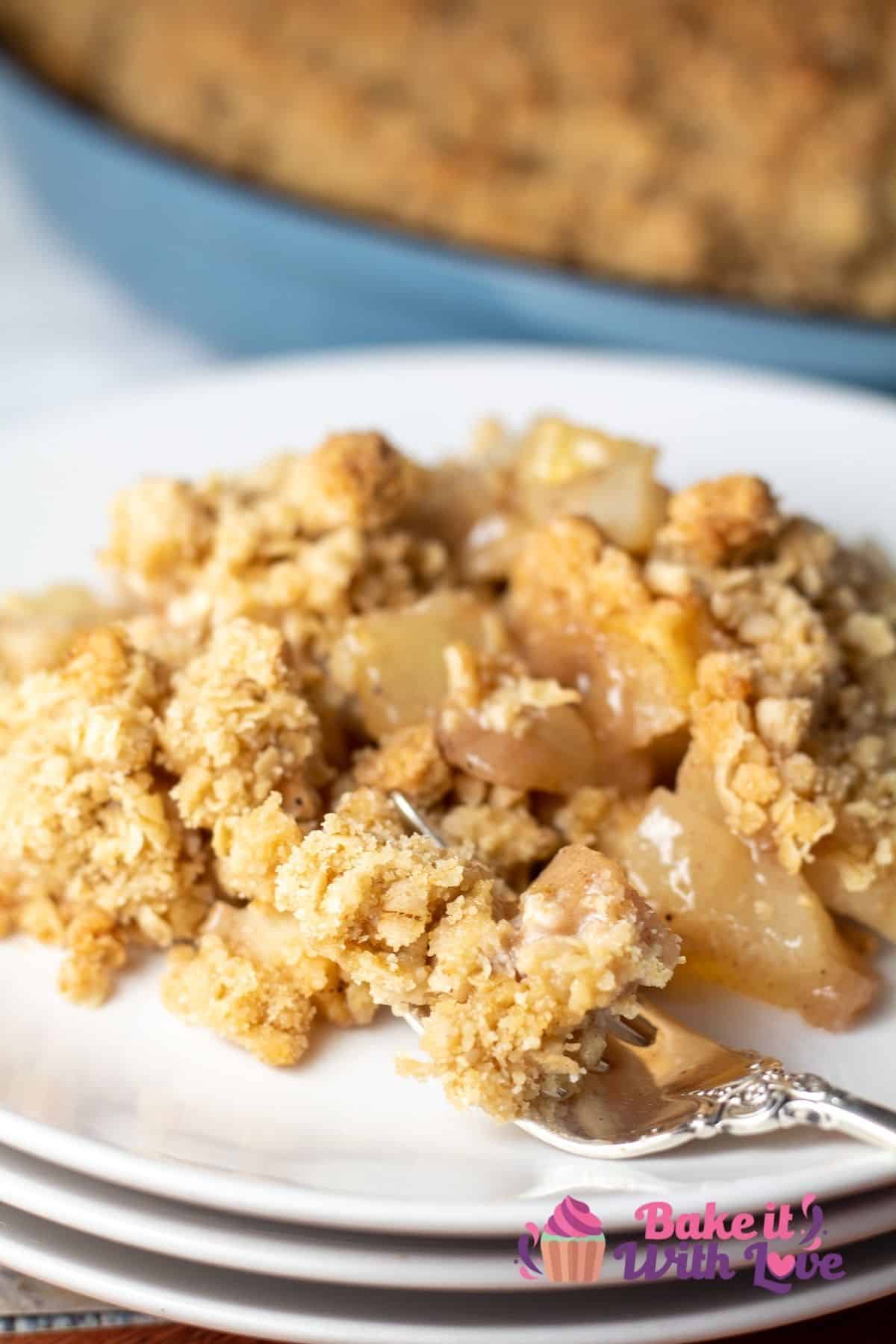 Tall image of pear crisp on a white plate.