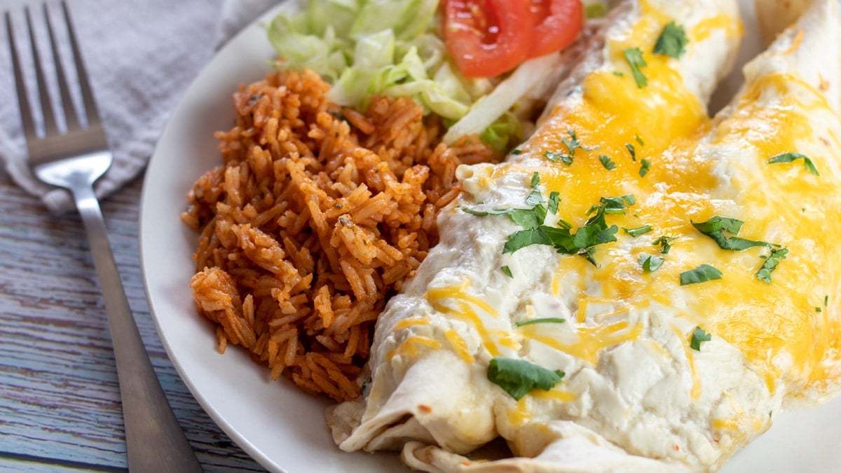 Wide image showing plate of sour cream enchiladas.