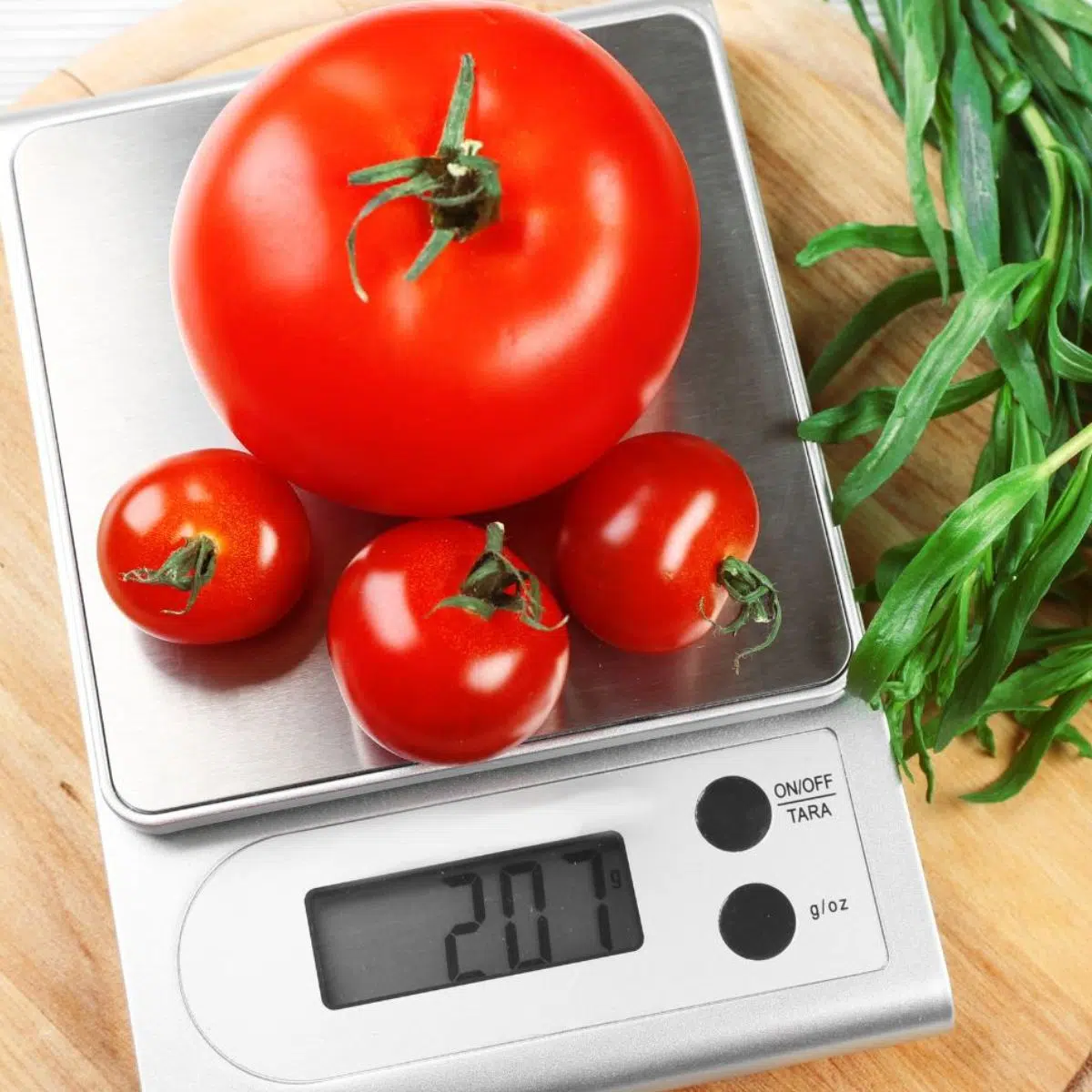 Konversi gram dalam satu pon untuk memasak dan memanggang diilustrasikan dengan timbangan dapur dan tomat segar ditimbang dalam gram.
