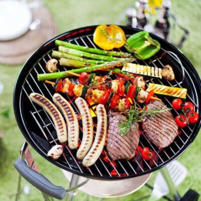 Grill temperature guide featuring an assortment of grilled foods on a weber grill.