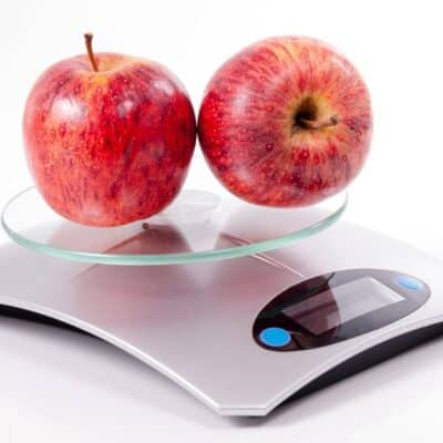 How many ounces in a pound conversion illustrated with apples on a kitchen scale.