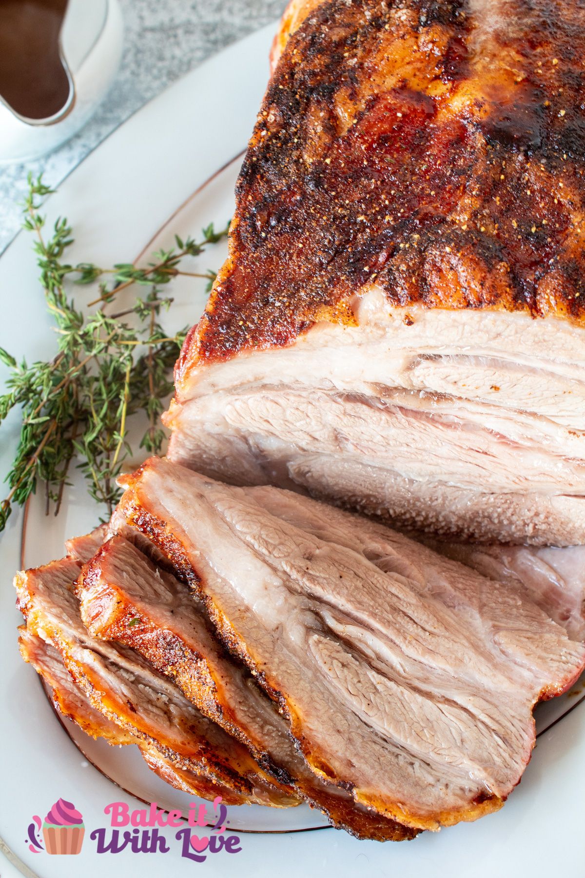 Tall image of pork shoulder butt roast on a serving dish sliced.