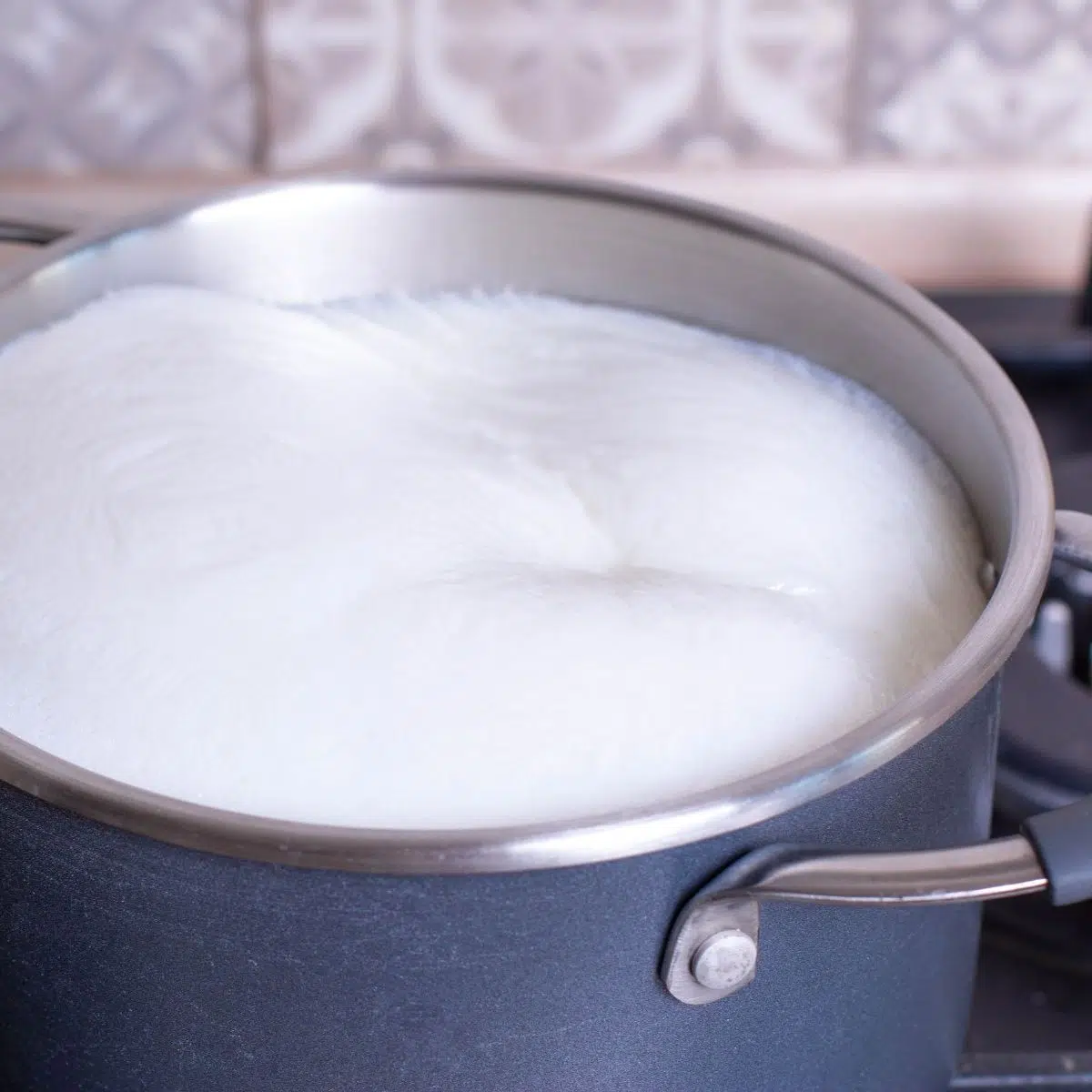 Cara cepat melecur susu untuk kentang tumbuk dengan susu dalam periuk.