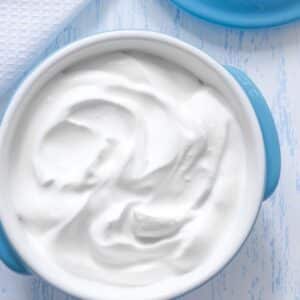 Pengganti yogurt terbaik dan alternatif untuk digunakan dengan yogurt segar dalam mangkuk biru.