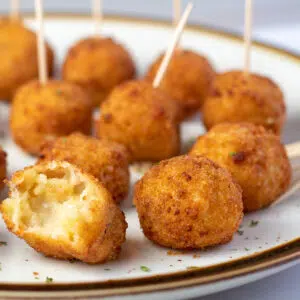 Square image of air fryer mac & cheese bites on a plate.