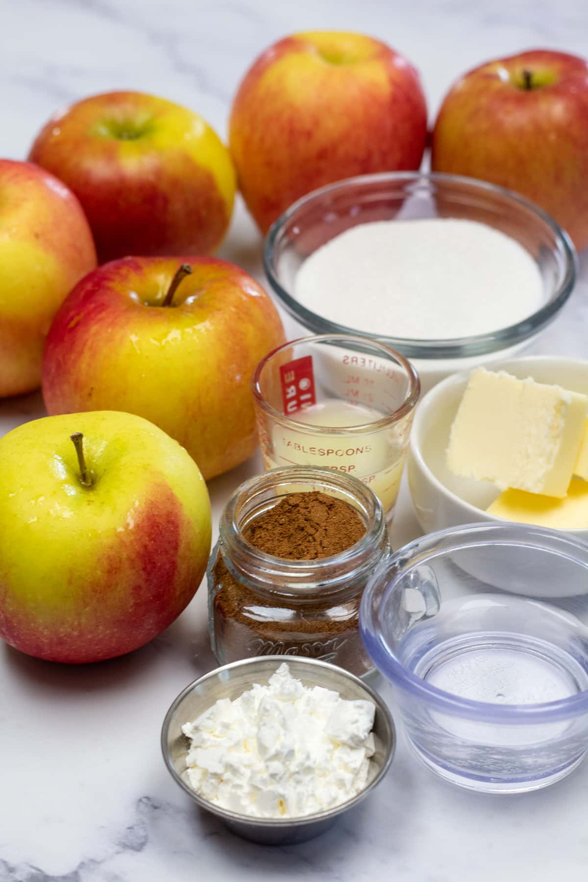 Grande photo montrant les ingrédients nécessaires à la fabrication d'une garniture pour tarte aux pommes.