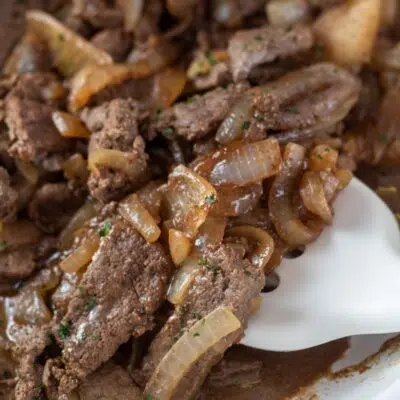 Pin image with text of beef liver and onions in a frying pan.
