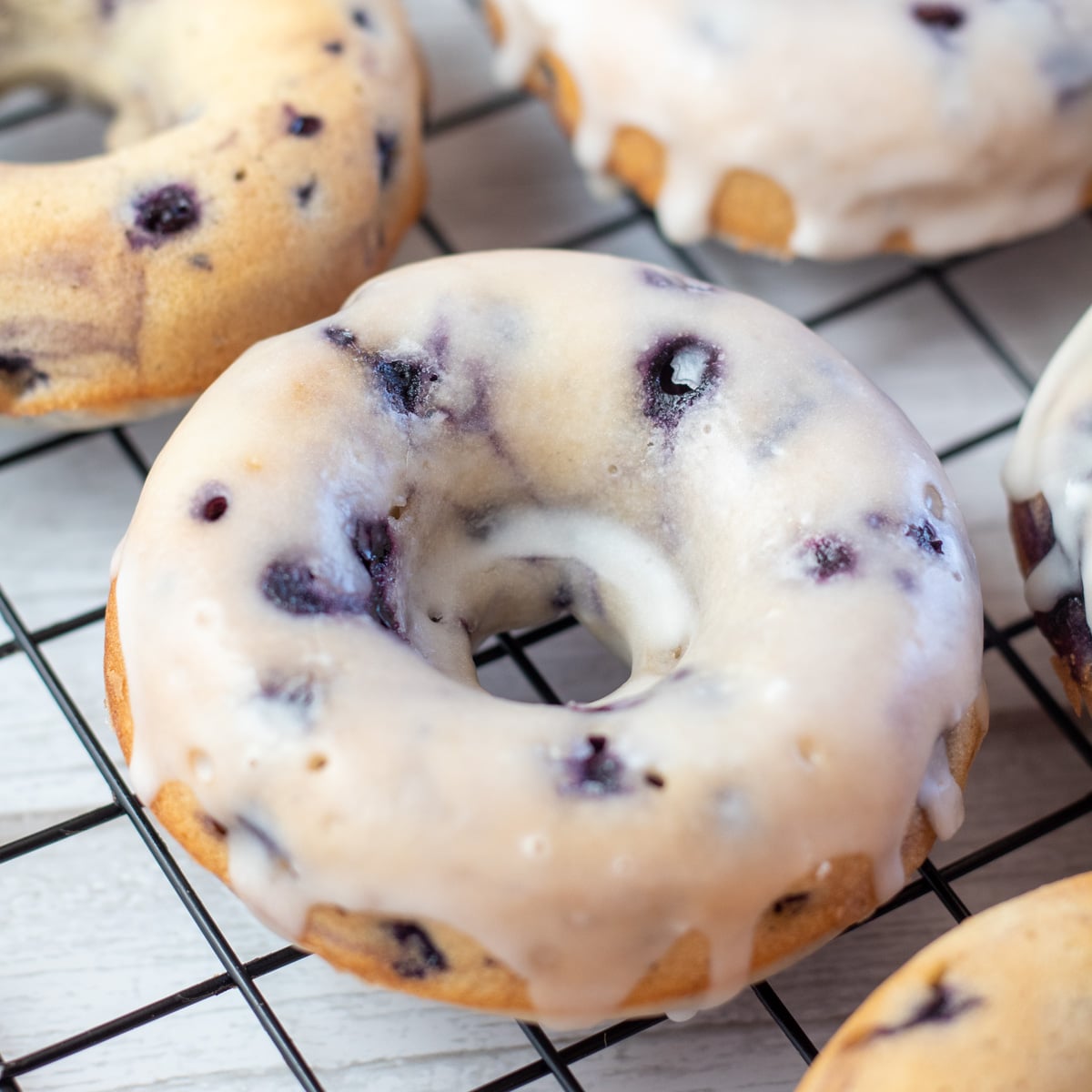 Square image of a baked blueberry donut.