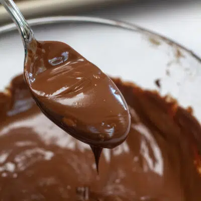 Square image of a spoon of chocolate icing for donuts.