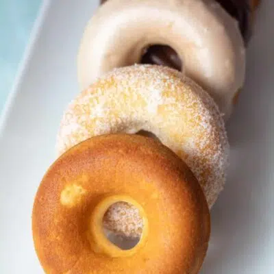 Tall image of an assortment of baked donuts.