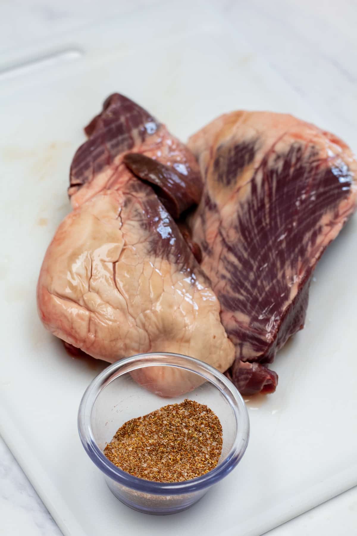 Tall image showing ingredients for beef heart steak.
