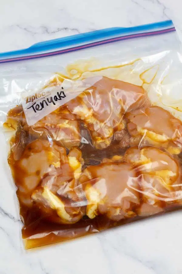 Process image 1 showing boneless chicken thighs in a ziplock bag marinating in teriyaki.