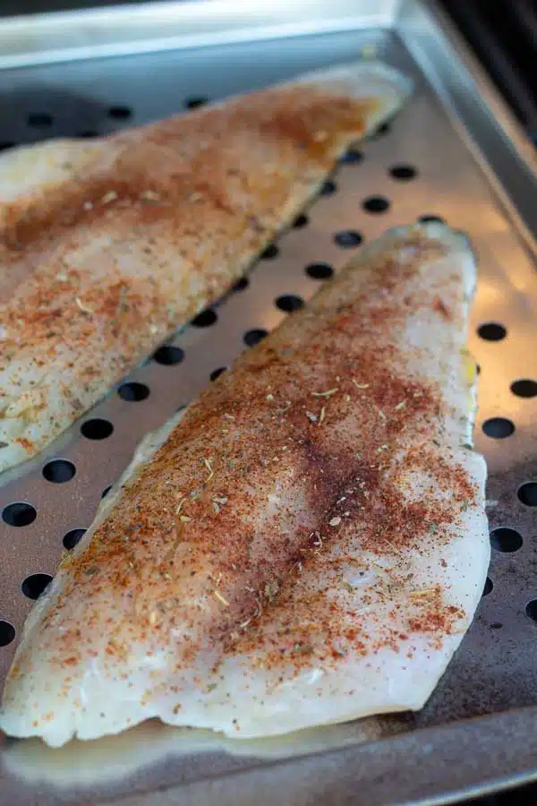 Process image 2 showing seasoned branzino fillets on a grill pan.