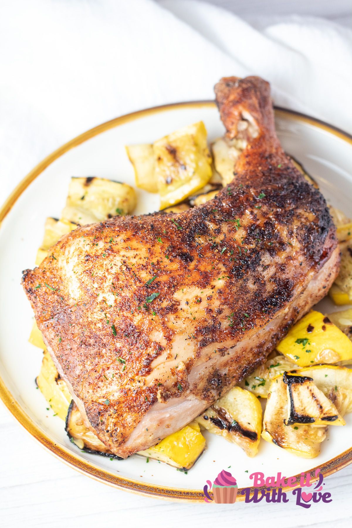 Tall image of grilled chicken leg quarters over sauteed yellow squash.