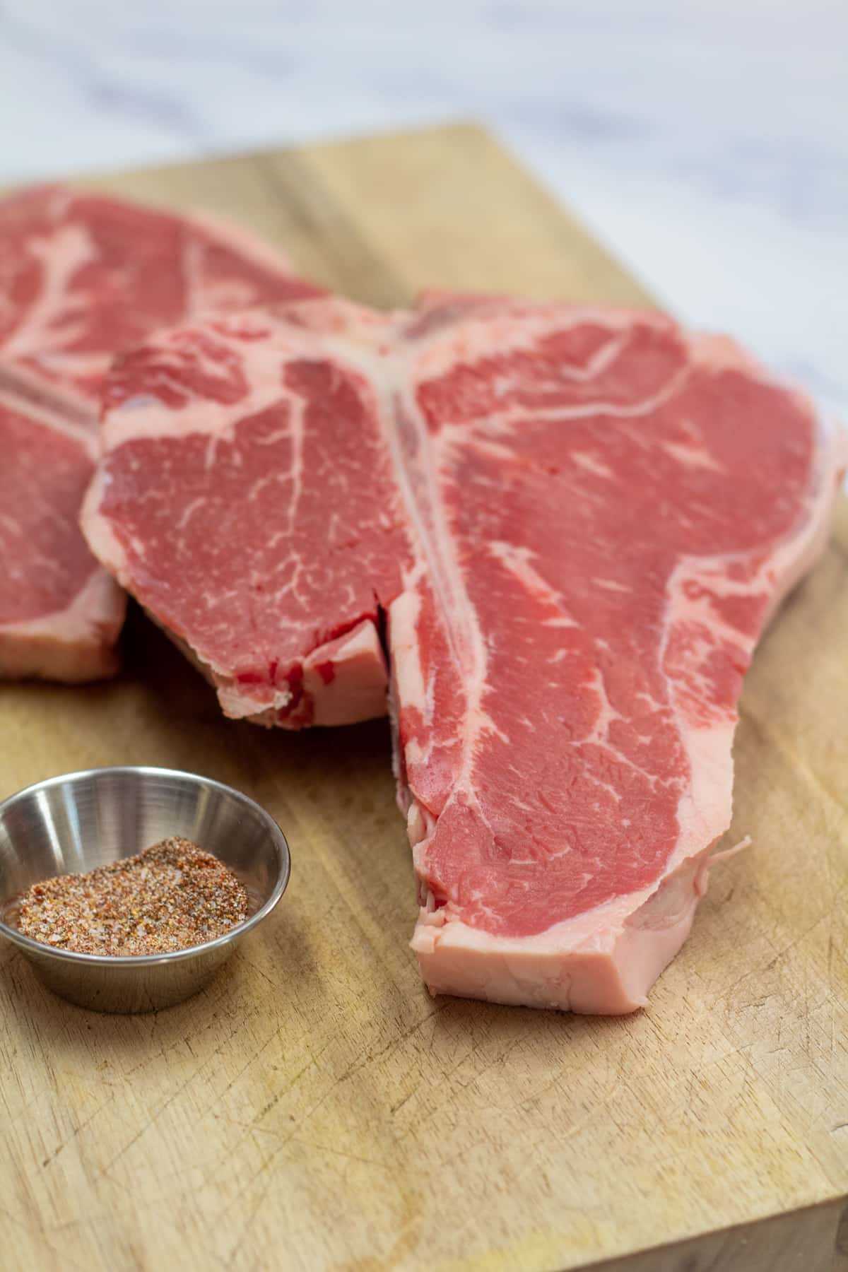 Photo showing ingredients of t-bone steak and seasoning.