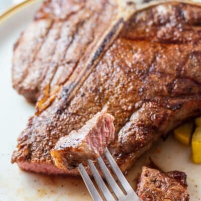 Pin image with text of a grilled t bone steak on a plate.