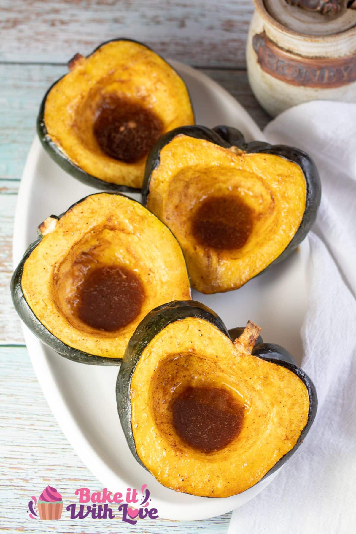 Tall image of honey roasted acorn squash in a baking dish.