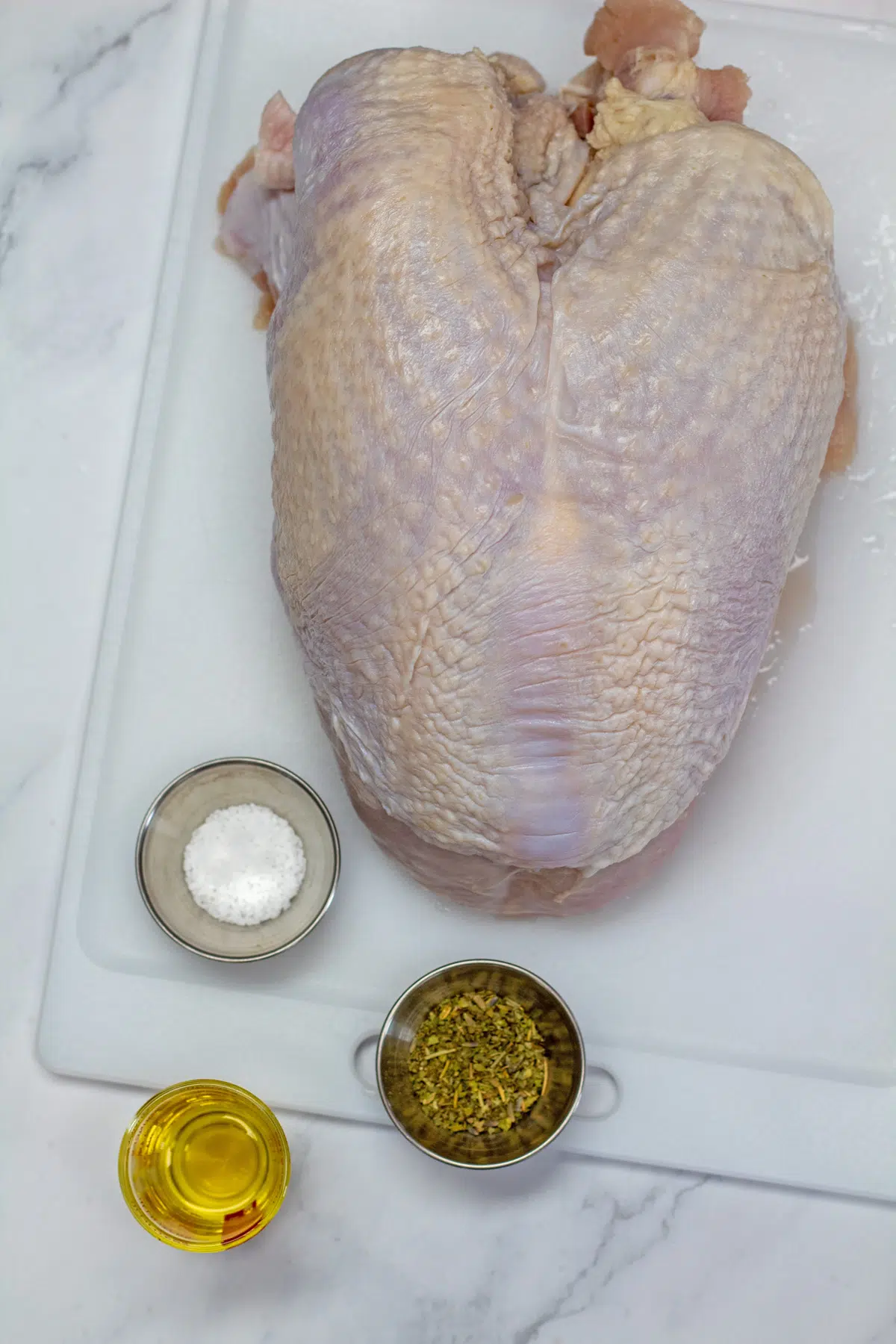 Oven roasted turkey breast ingredients with bone-in skin-on turkey breast, olive oil, salt, and poultry seasoning.