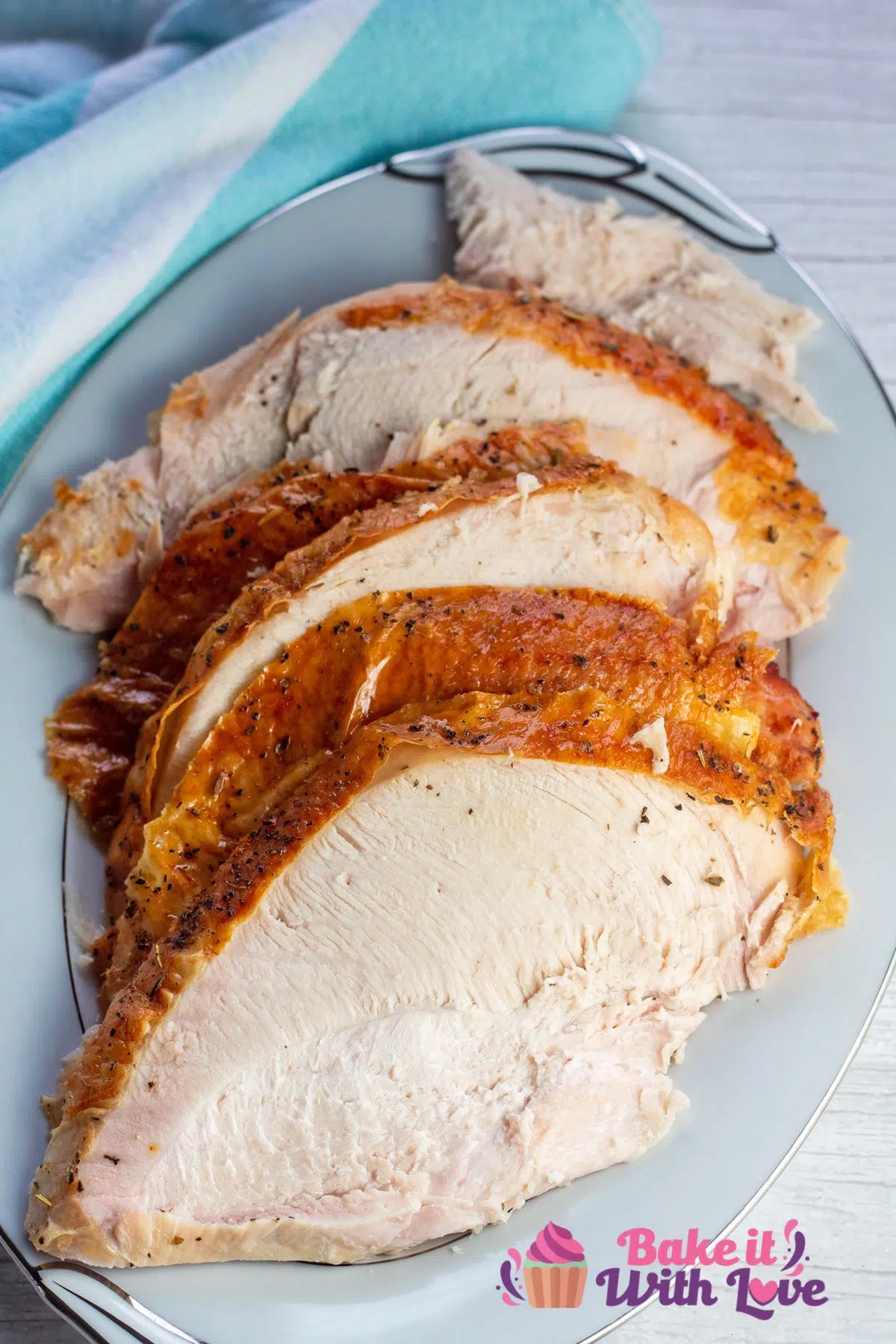 Best oven roasted turkey breast sliced and served on white serving platter.