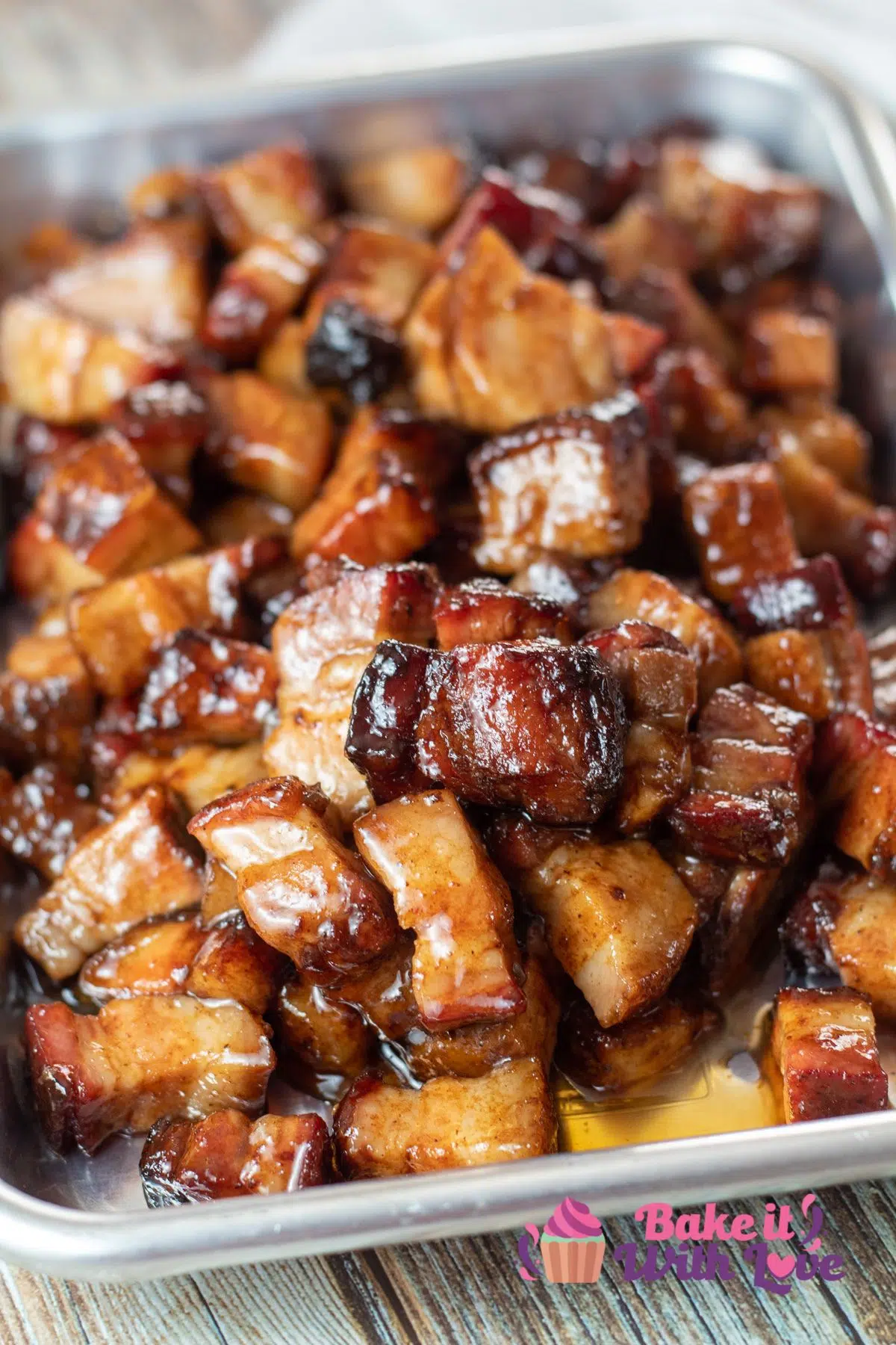 Tall image of pork belly burnt ends on a small baking tray.