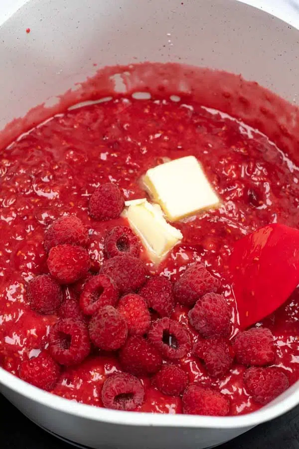 Process image 3 showing added raspberries and butter into pie filling mixture.