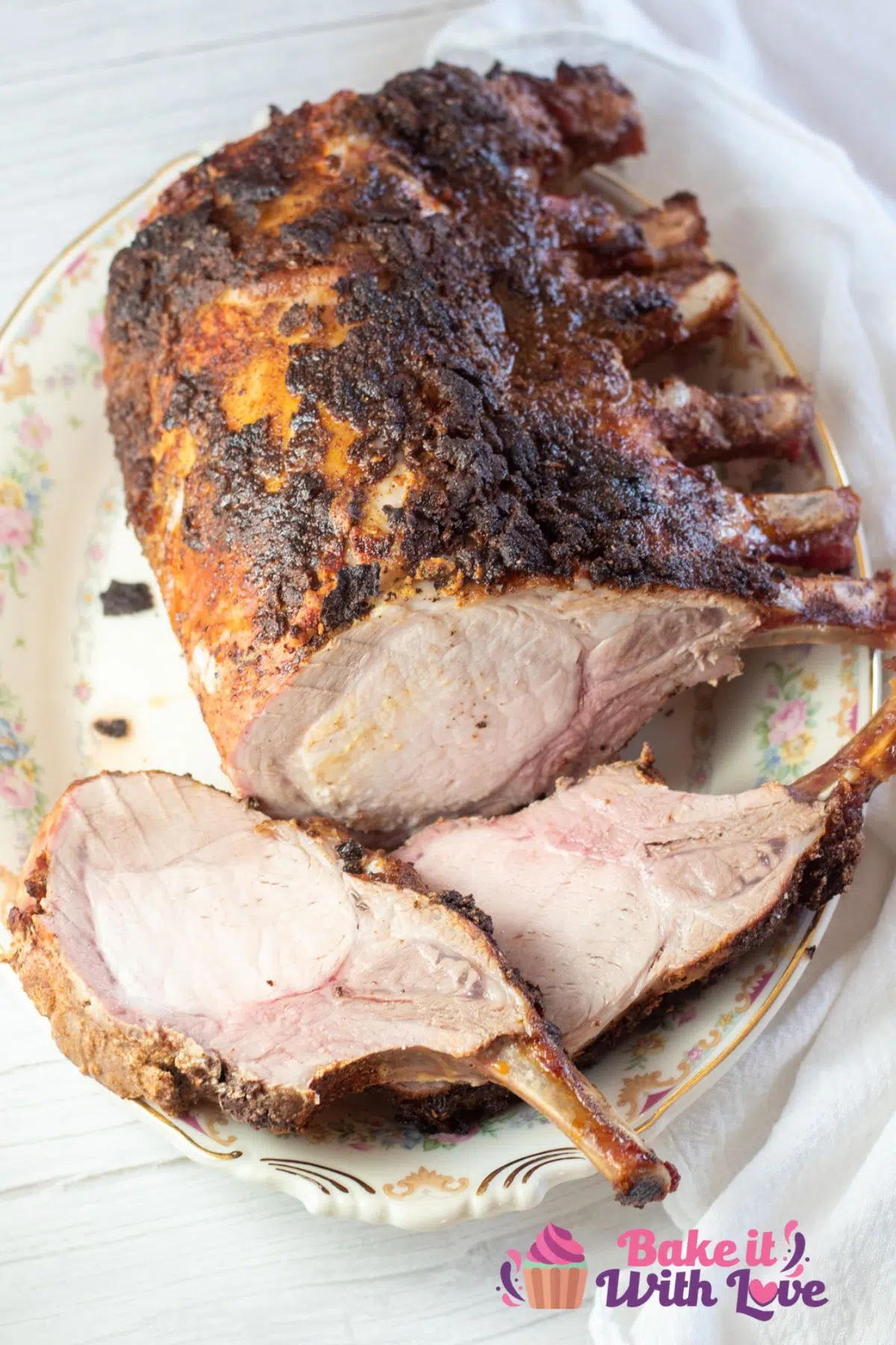 Tall image of sliced rack of pork on a serving platter.