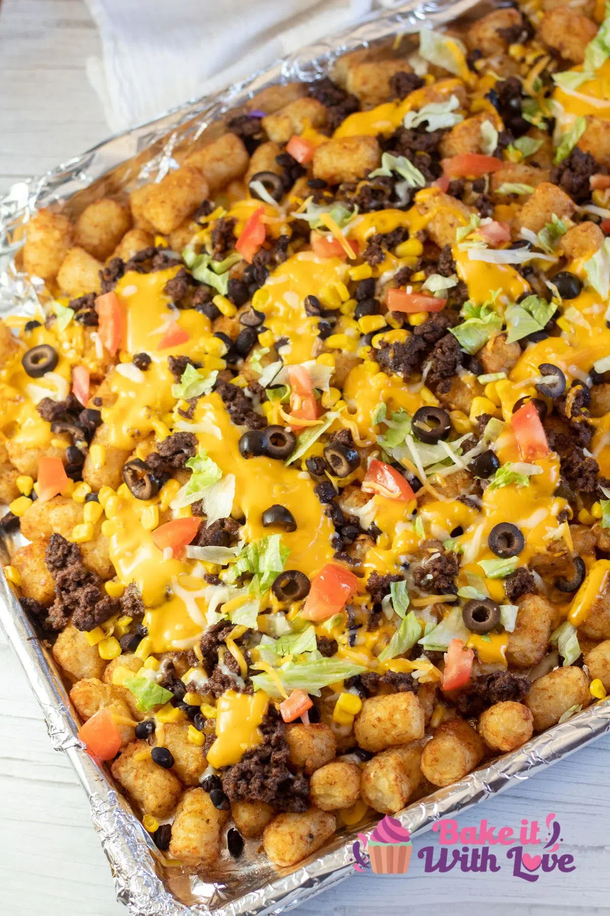 Tall image of totchos on a baking sheet.