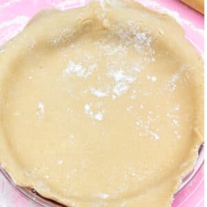 Square image of pie dough in pan.