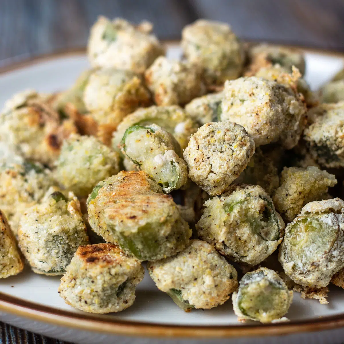 Square image of breaded air fryer okra on a plate.