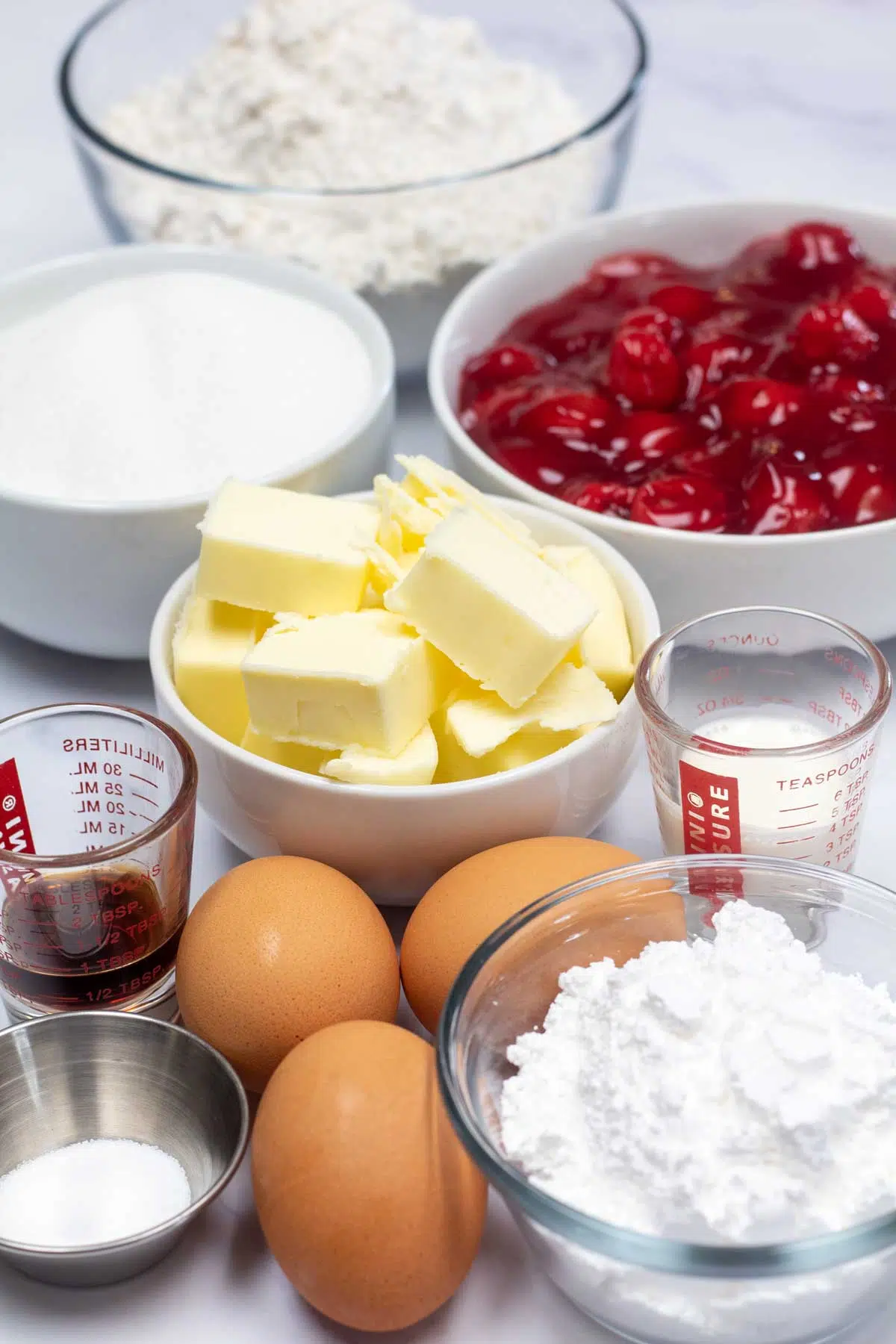 Tall image showing all the ingredients to make cherry pie bars.