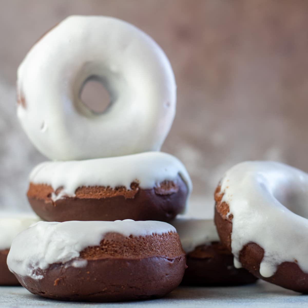 Firkantet billede af chokoladebagte donuts.