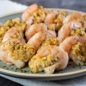 Square image of crab stuffed shrimp on plate.
