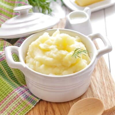 Square image of mashed potatoes in a white cooking bowl.