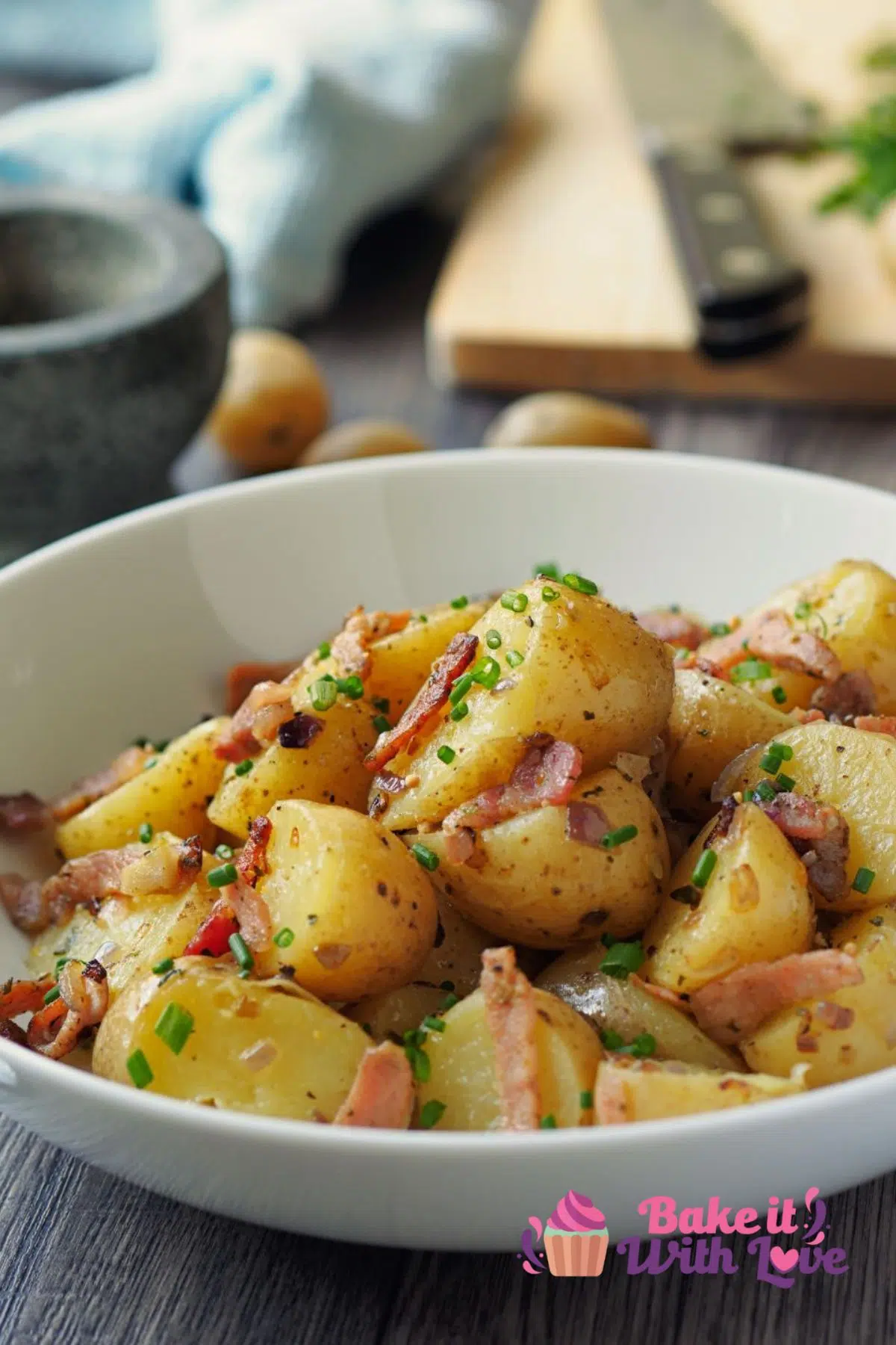 Tall image of german potato salad in a white bowl.
