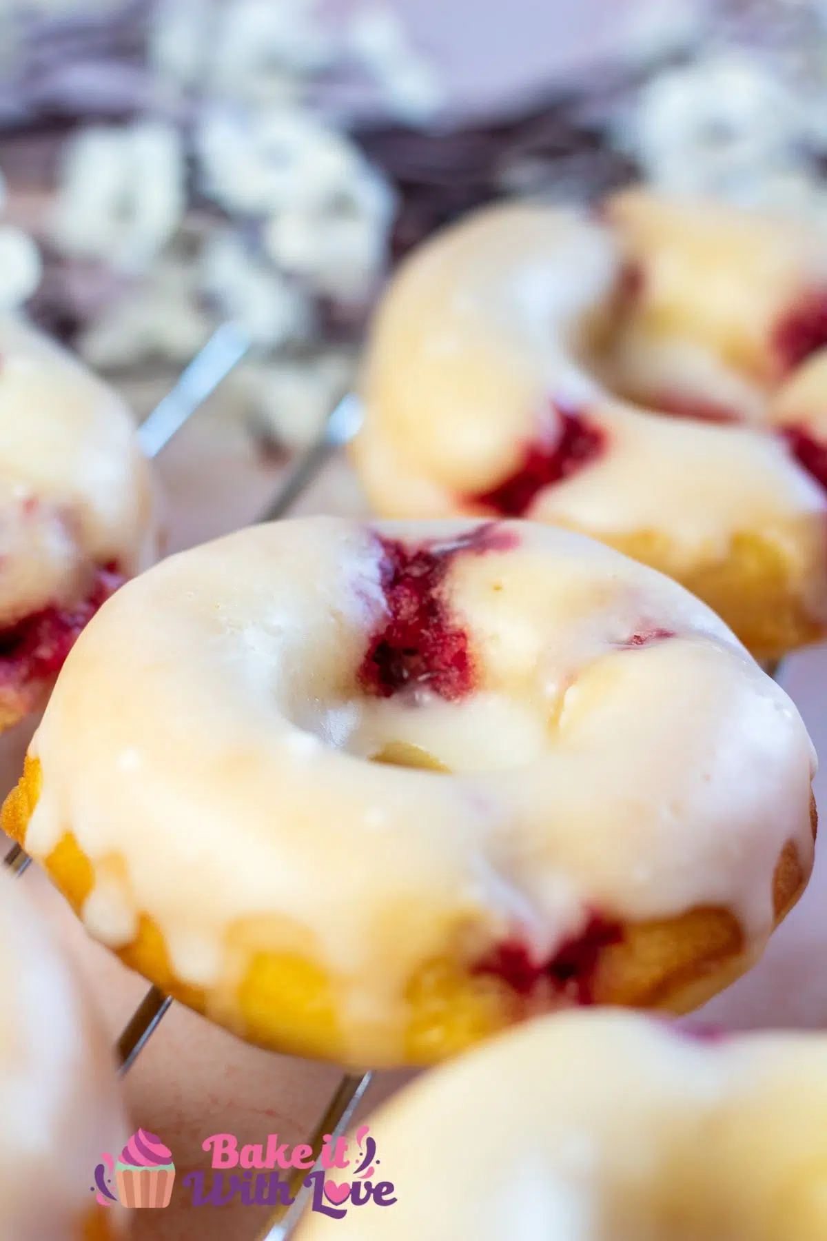 Tall image of raspberry lemon baked donuts.