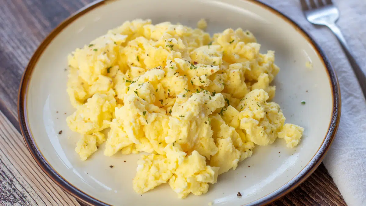 Wide image of microwaved scrambled eggs on a plate.