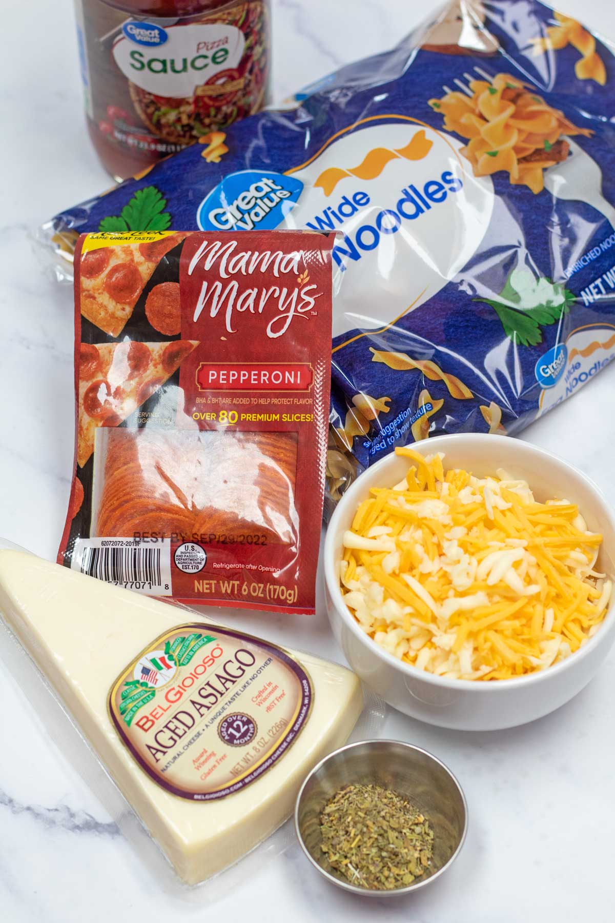 Tall image of ingredients needed for pepperoni pizza casserole.