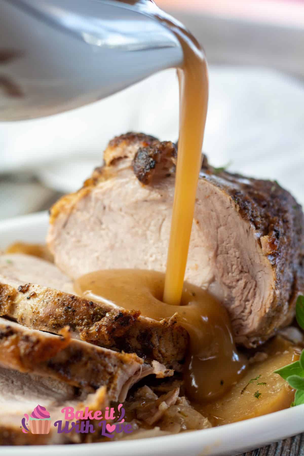 Tall image of a gravy boat full of pork gravy.