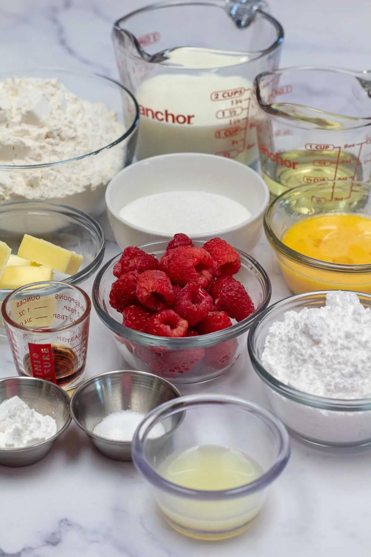Tall image of ingredients needed for raspberry lemon baked donuts.