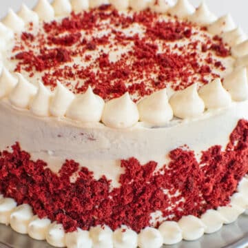 Široký obraz červeného sametového dortu s polevou ze smetanového sýra.