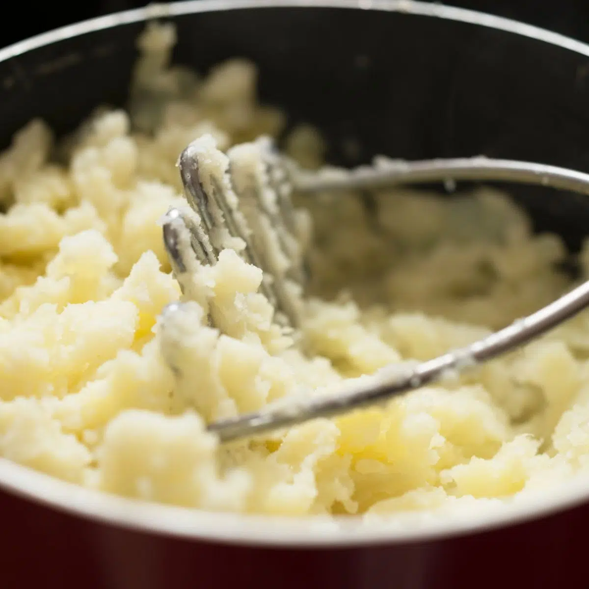 Square image of mashed potatoes in a pot.