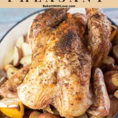 Pin image with text of roasted pheasant in roasting pan with potatoes and lemons.