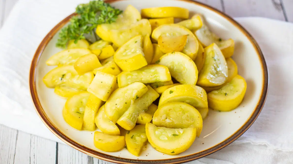 Wide image of a plate with sauteed yellow squash.