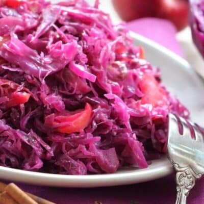 Pin image with text of sweet and sour red cabbage on a serving dish.