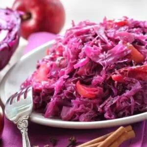 Square image of sweet and sour red cabbage on a serving dish.