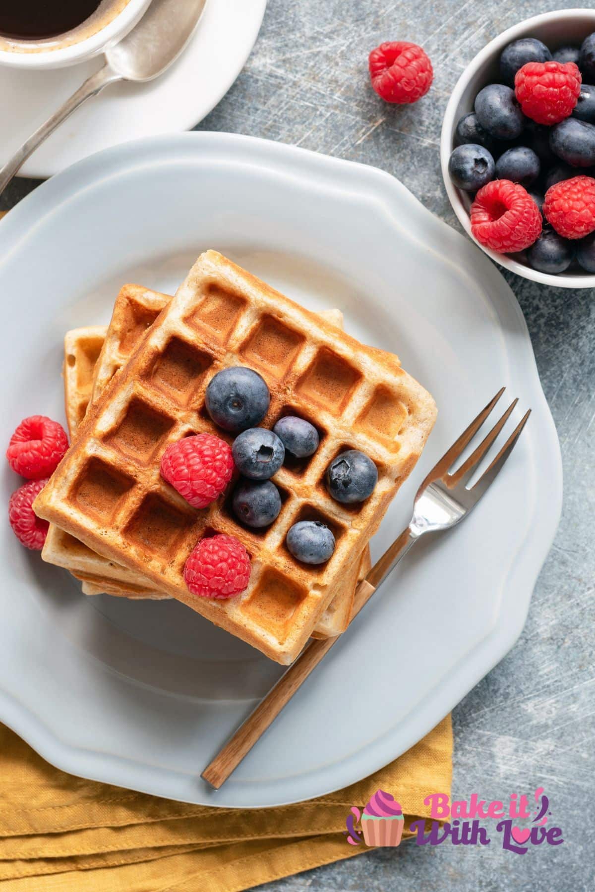 Tall image showing waffles with fruit and syrup.
