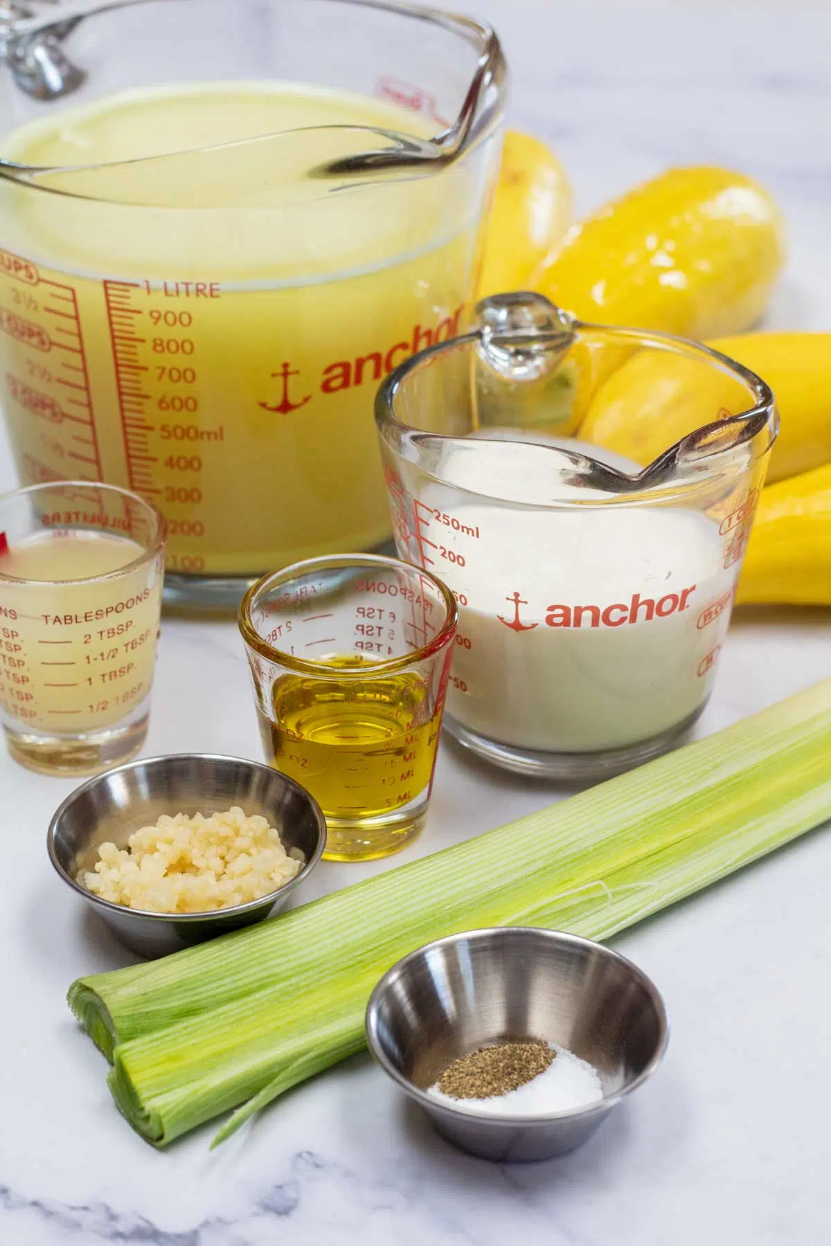 Tall image showing all the ingredients needed for yellow squash soup.