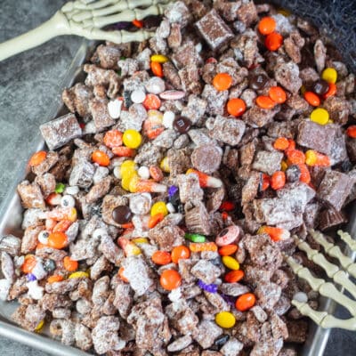Square image of a tray of Halloween muddy buddies.