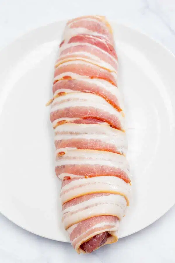 Process image 3 showing pork tenderloin rolled in bacon.