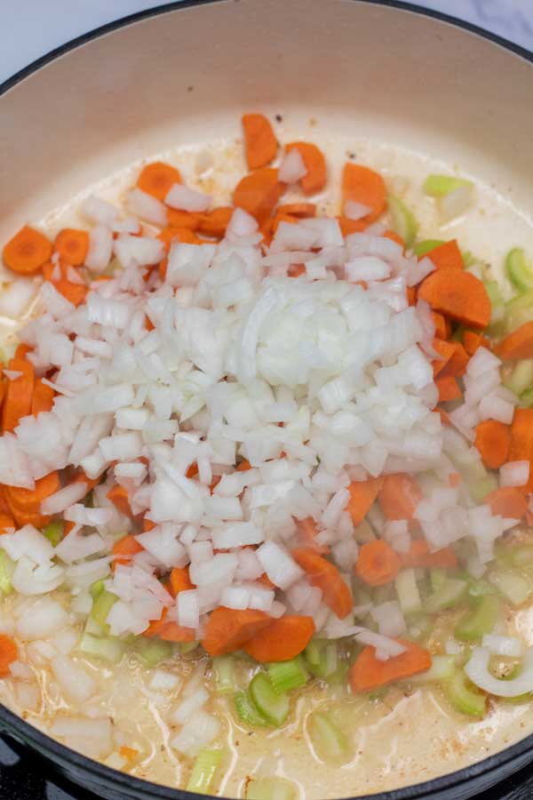 Process image 2 showing onions, carrots and celery sauteing in pan.
